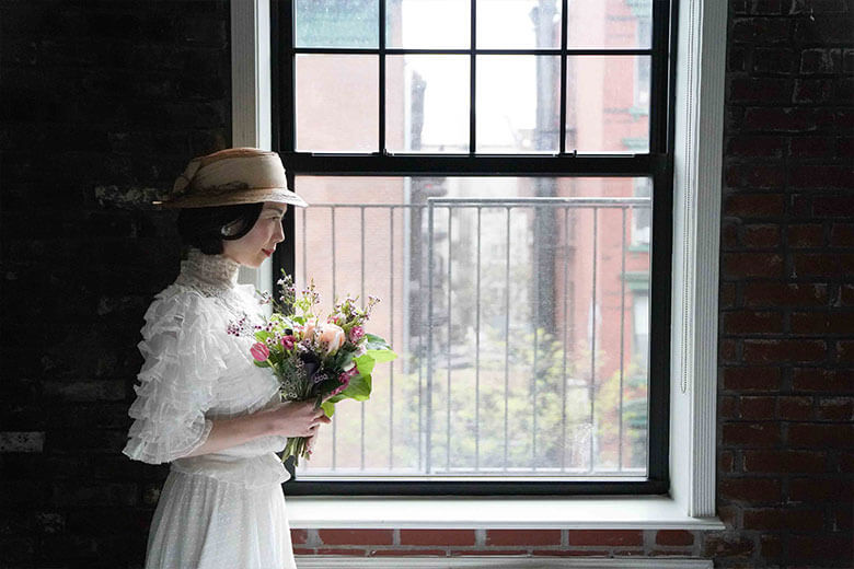 窓際に立つ白い服を着た女性